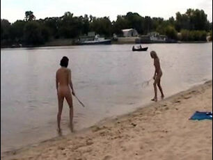 Slim nude teenages toying badminton on a sea beach.